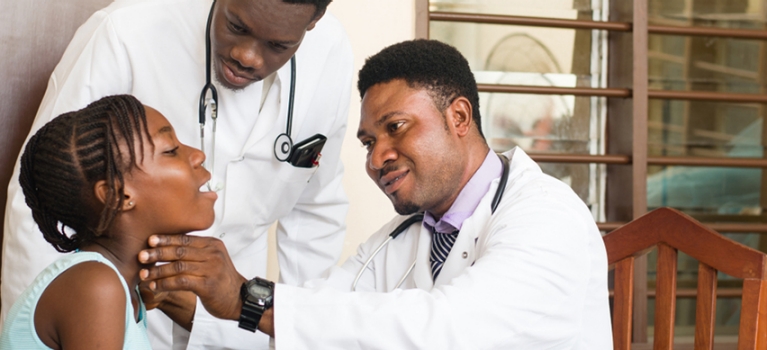 Doctors examining young female patient in an African clinic