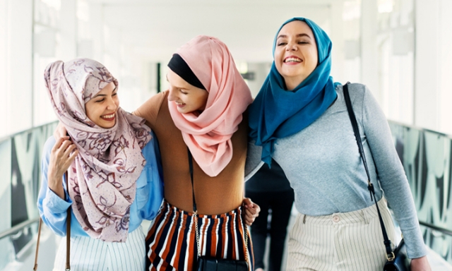 Muslim female friends walking through an airport together